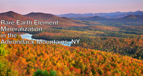 Autumn landscape of the Adirondack mountains at golden hour with orange-yellow trees carpeting mountainsides..